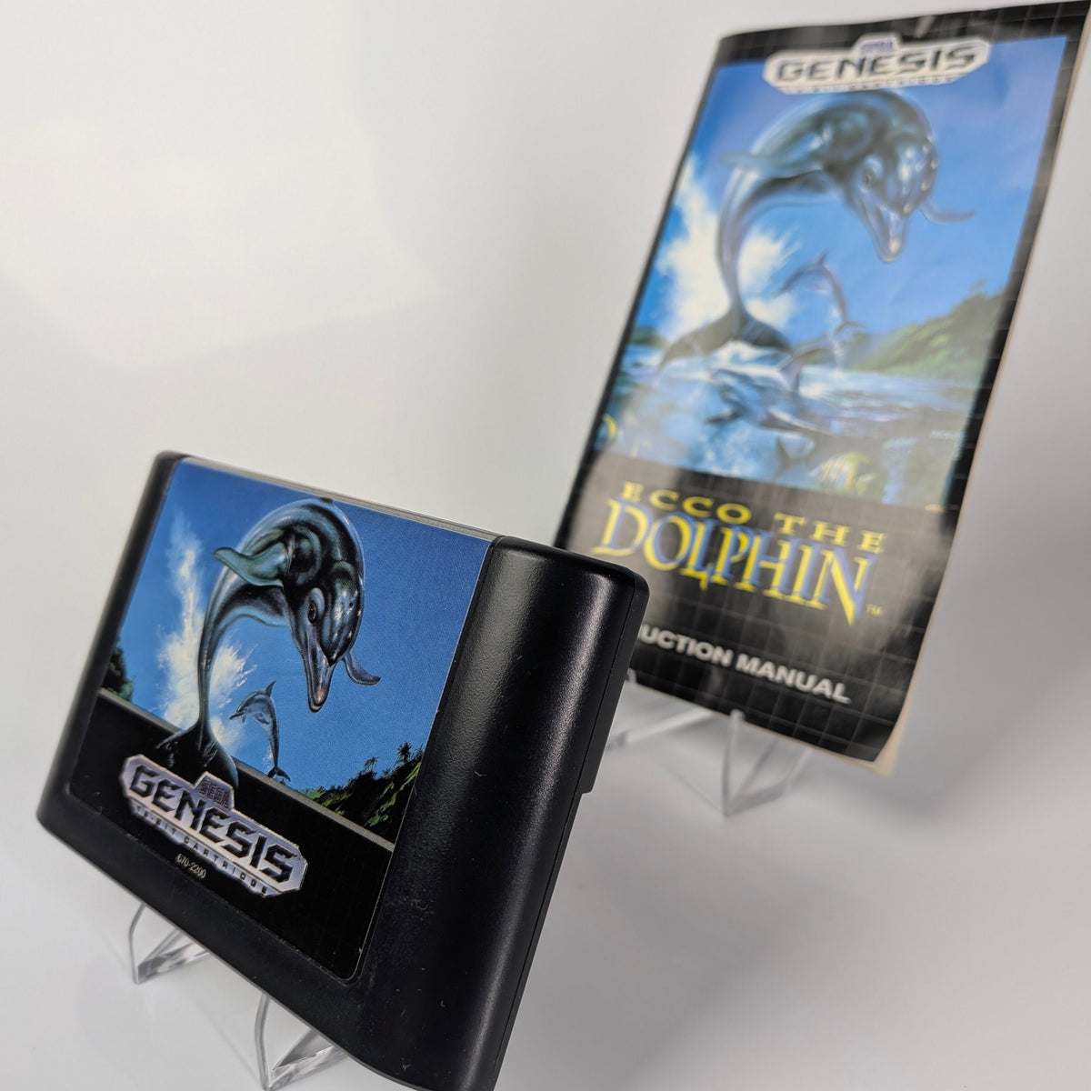 Ecco the Dolphin game cartridge and manual for Sega Genesis on a white background