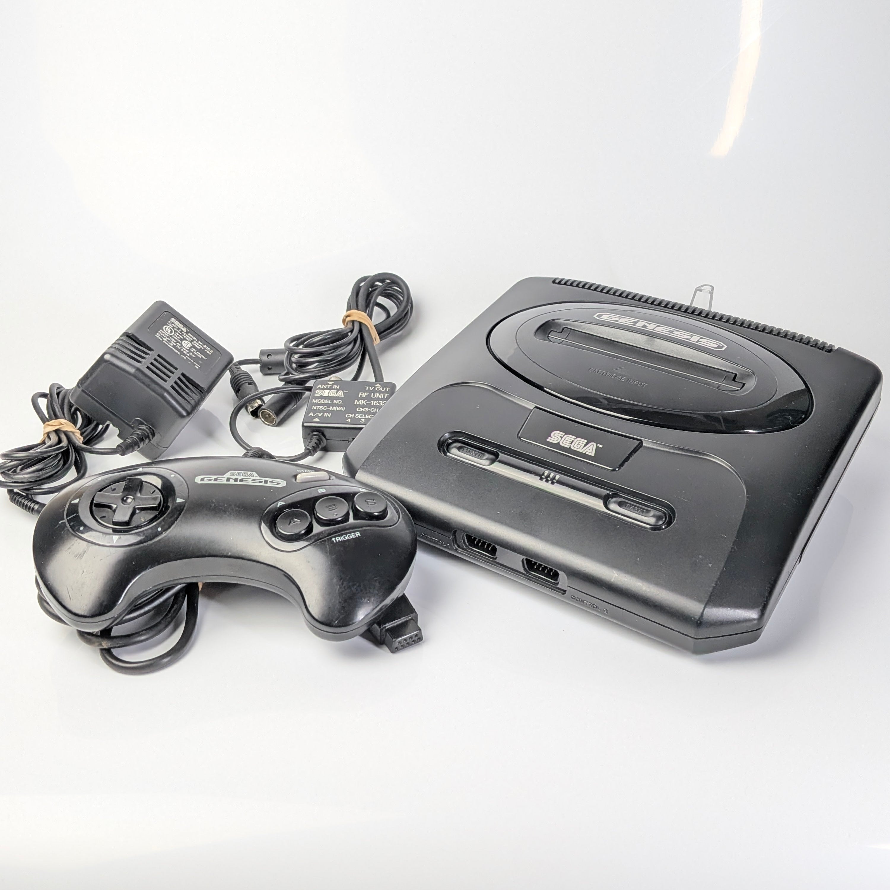 Sega Genesis console with controller on a white background