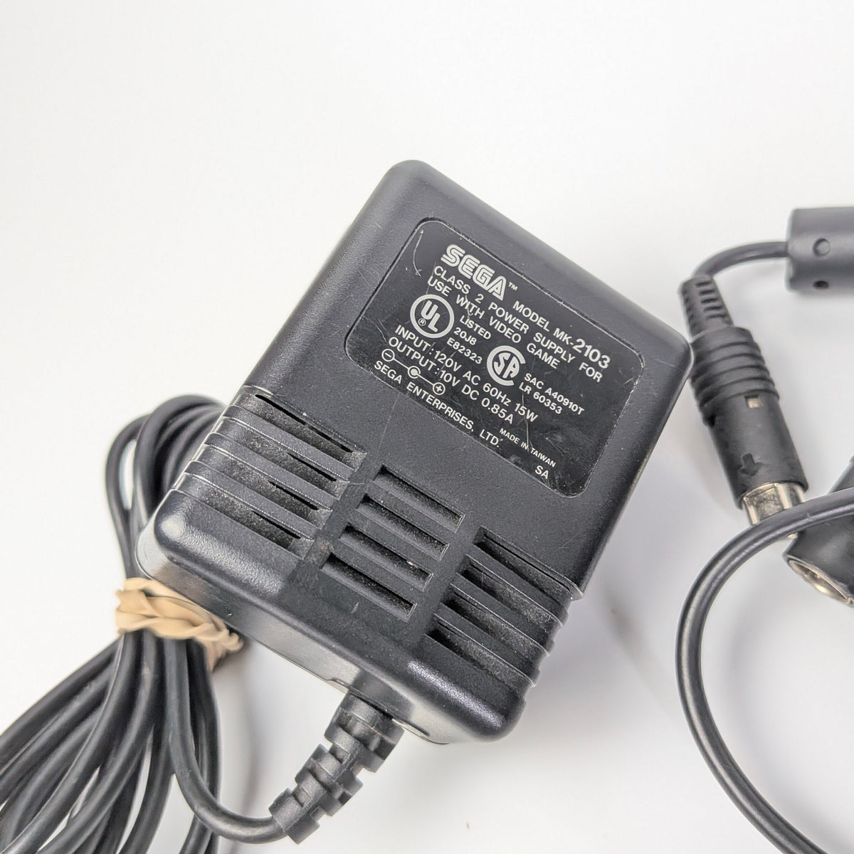 Black power adapter with Sega logo on a white background
