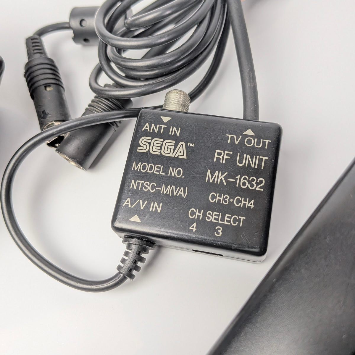 Sega RF unit with coiled cable on a white background