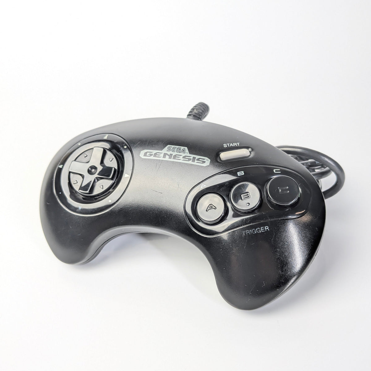 Black Sega Genesis gaming controller on a white background