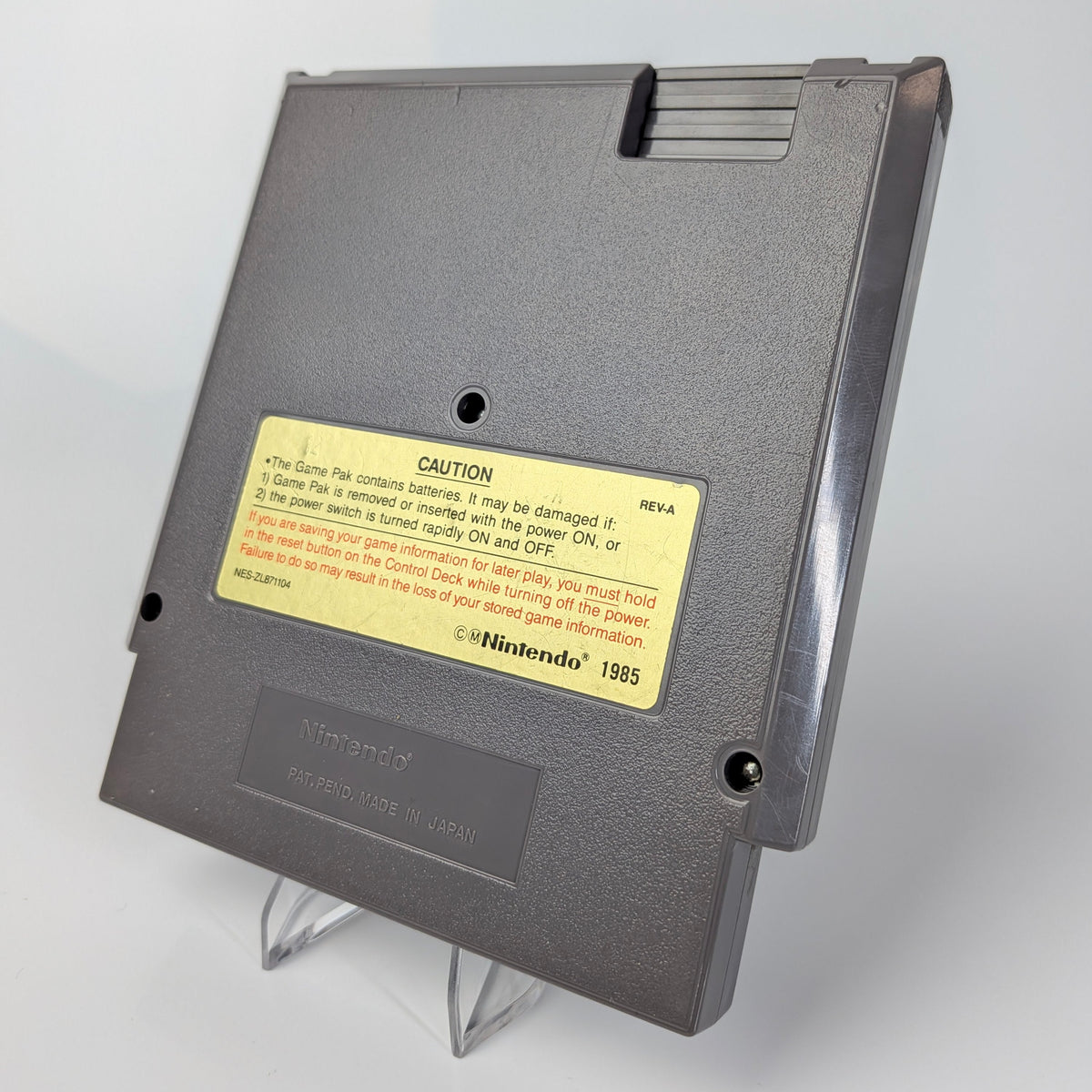 Gray floppy disk with a yellow label on a white background