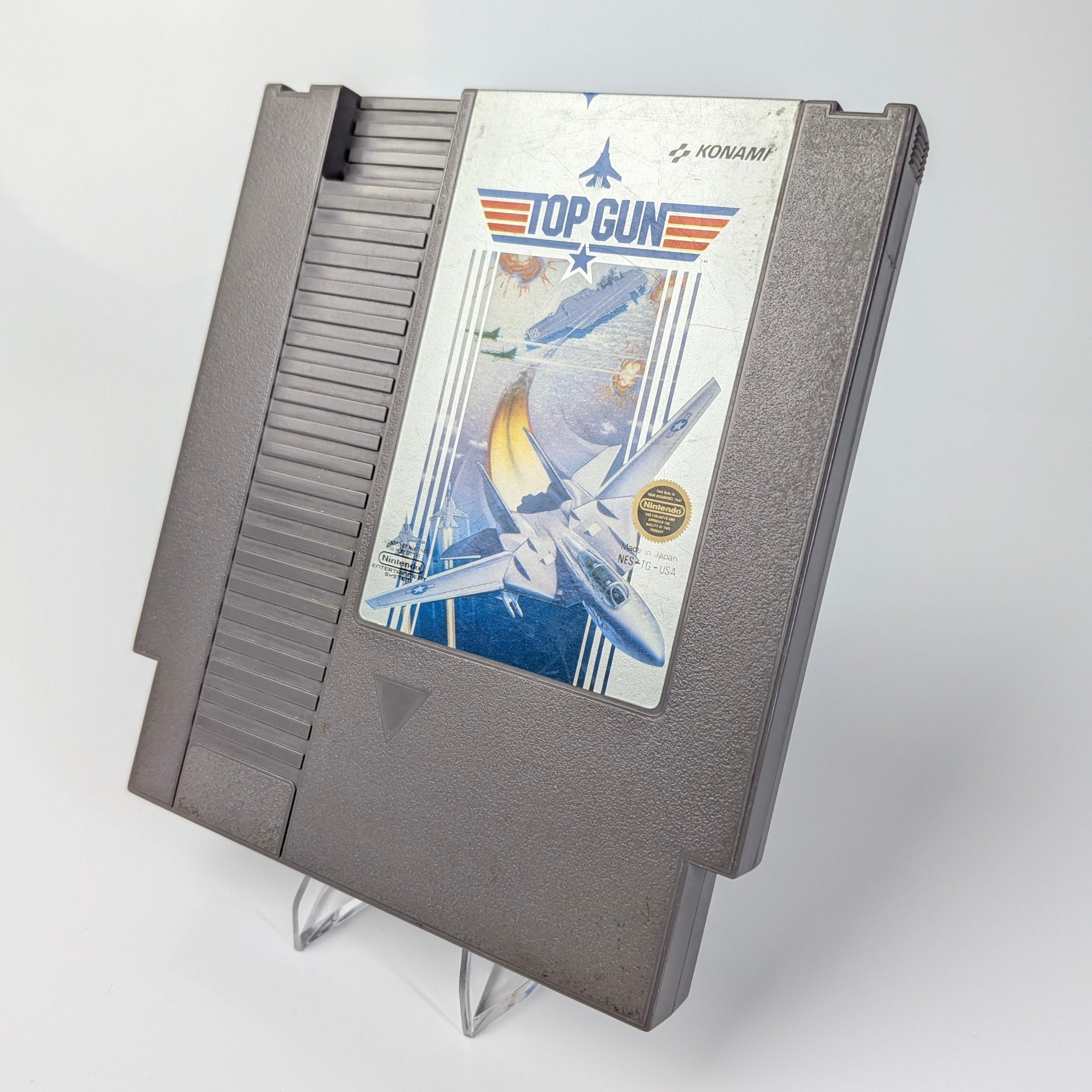 Nintendo Entertainment System game cartridge with 'Top Gun' cover on a white background