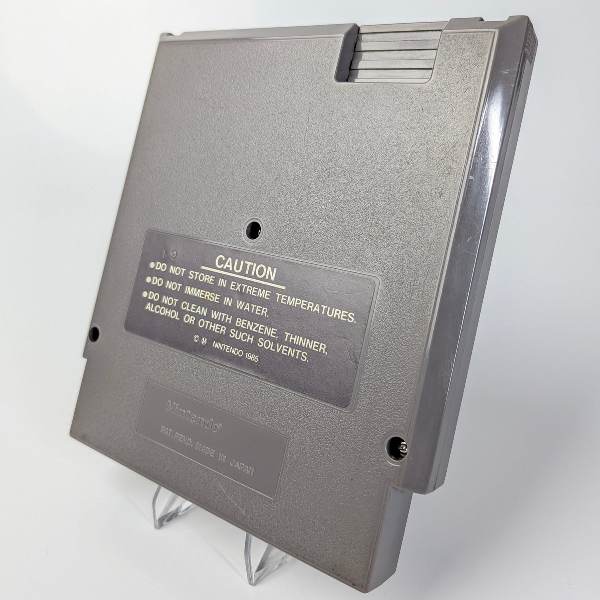 Gray floppy disk with a caution label on a white background