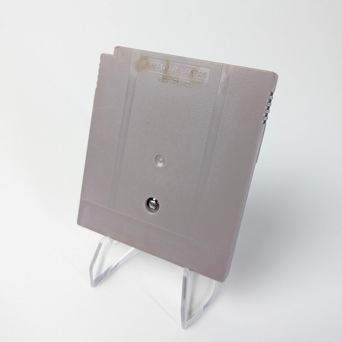 Gray floppy disk on a white stand against a white background