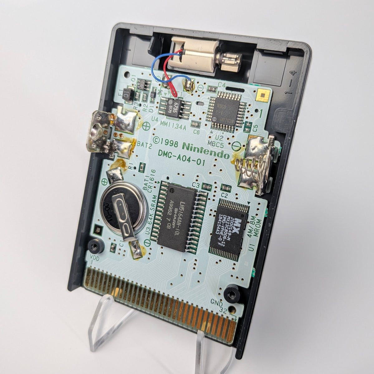 Close-up of a Nintendo Game Boy with its back cover removed, showing the internal components.