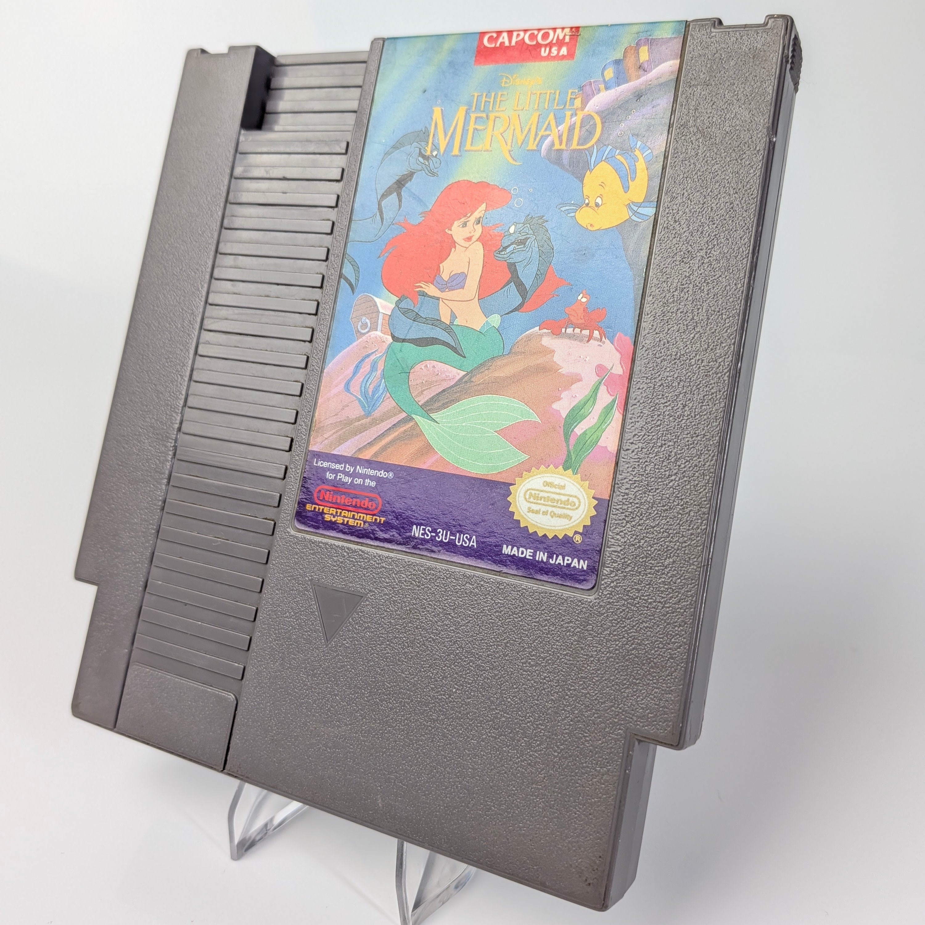 Nintendo Entertainment System game cartridge with 'The Little Mermaid' cover on a white background