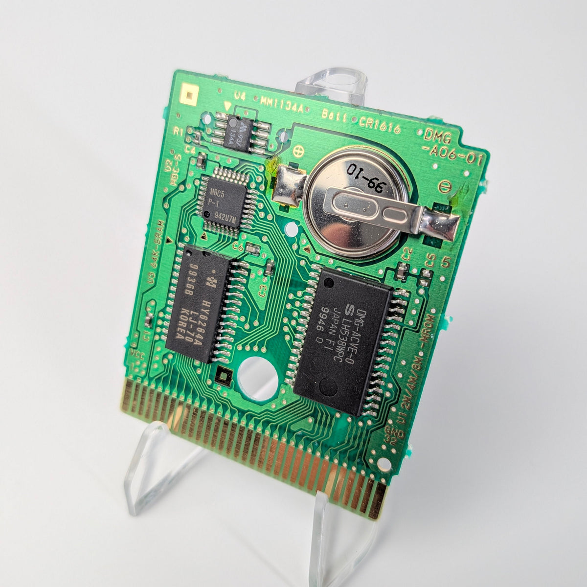 Green electronic circuit board on a stand against a white background