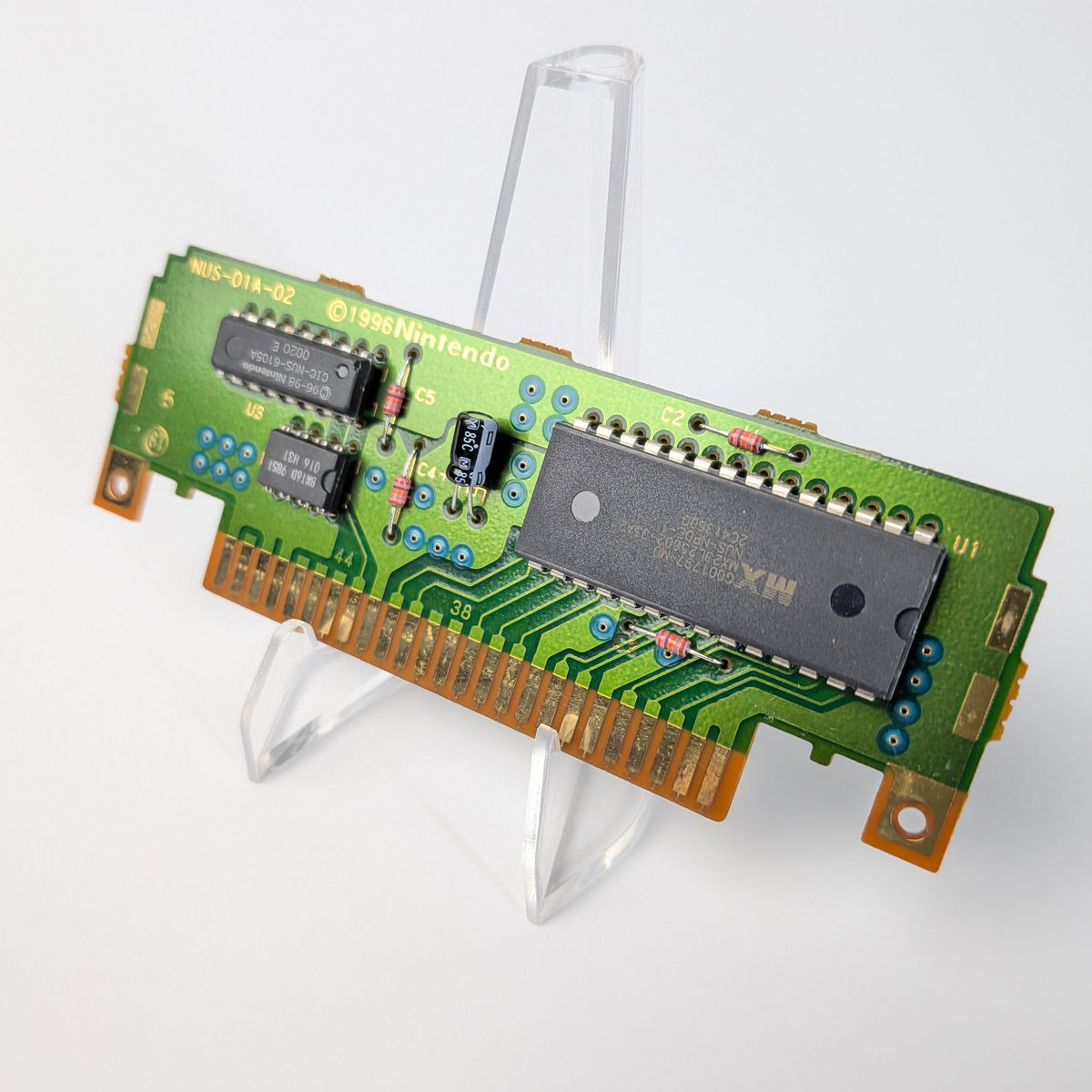 Green electronic circuit board on a stand against a white background