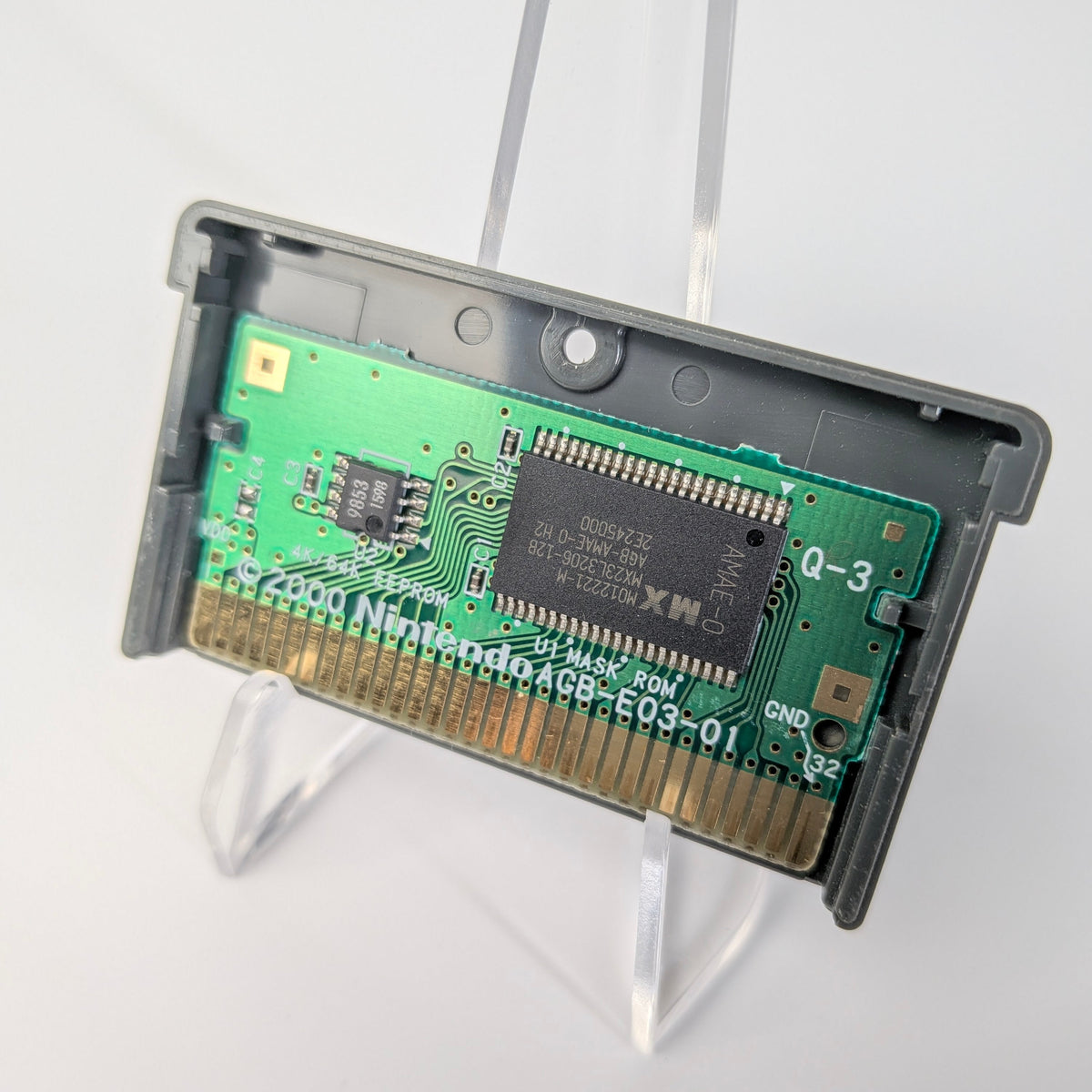 Nintendo Game Boy Color cartridge on a stand with a white background