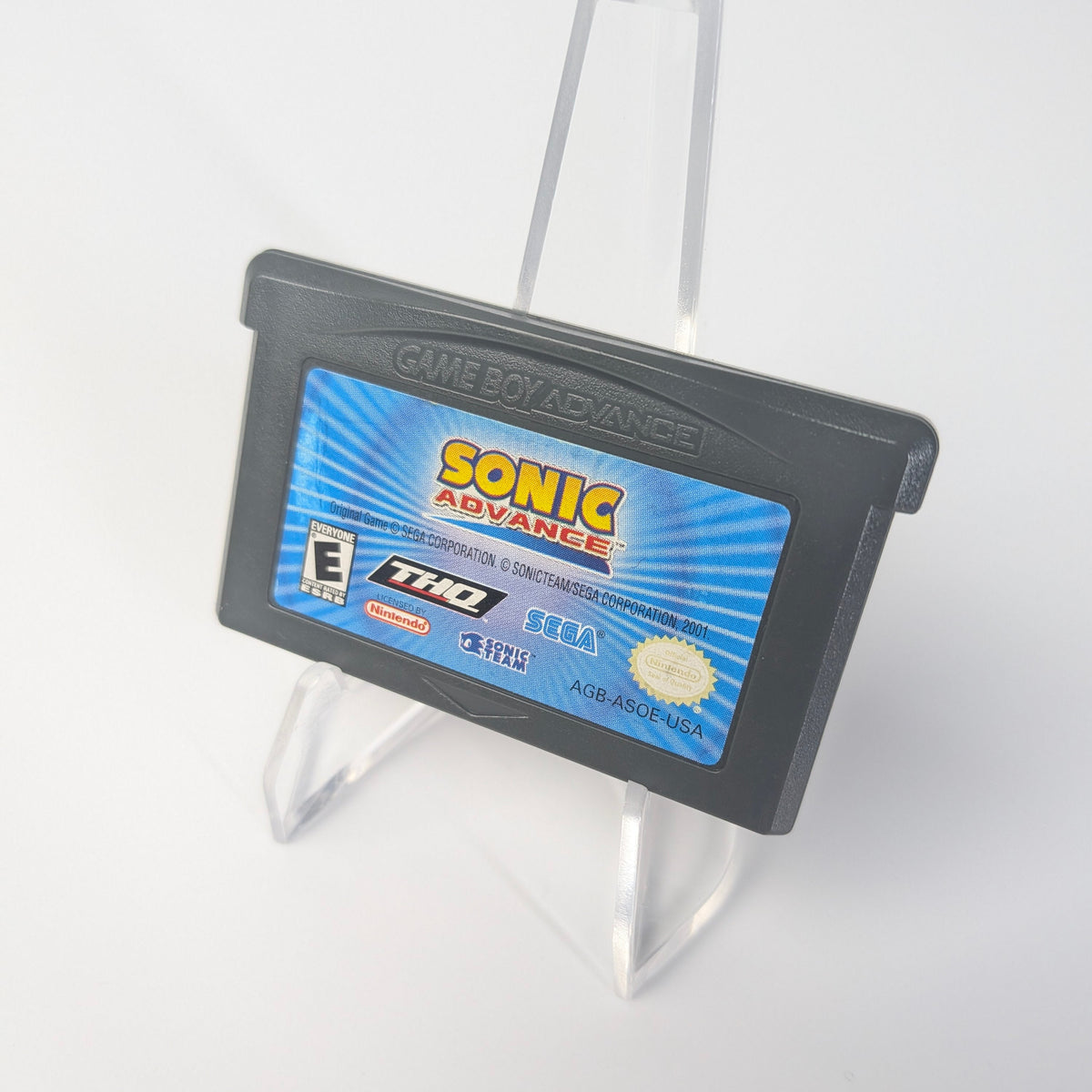 Game cartridge for 'Sonic Advance' on a stand against a white background