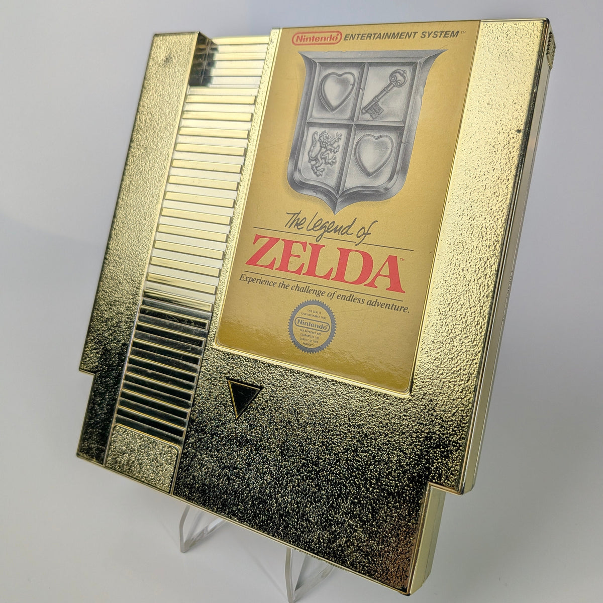 Gold cartridge of 'The Legend of Zelda' for Nintendo Entertainment System on a gray background